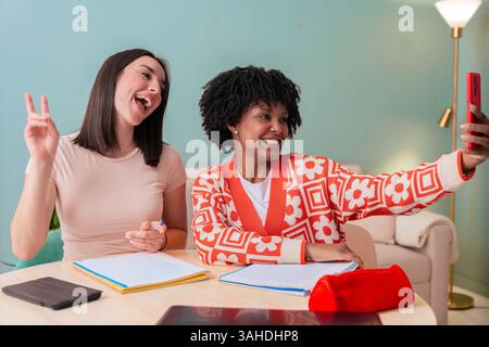 African American and Caucasian students taking selfie while studying at home Stock Photo