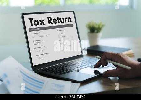 tax return  Business person using a laptop Tax season is approaching, and businesses must file their income return online to meet government deadlines Stock Photo