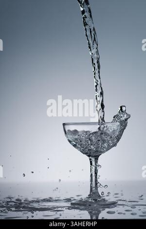 puring refreshment freshness drinking water on clean transperence glass in studio back light Stock Photo