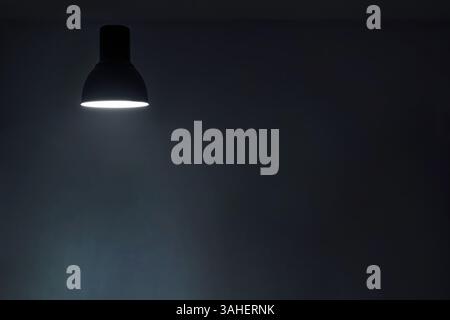 a shining levitating hanged ceiling lamp without electric wire  with dark blue tone dirty concrete background wall Stock Photo