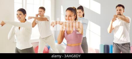 Happy smiling people doing boxing sport exercise in gym during workout. Stock Photo