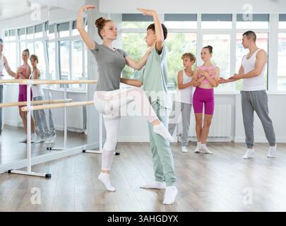 Ballet studio - teenagers girls and boys learn ballet movements in pairs Stock Photo