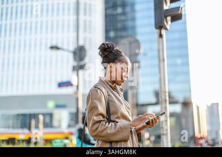 Confident mature business woman using mobile phone in the city Stock Photo