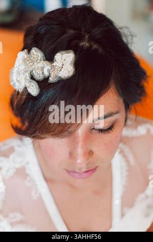 close up portrait of young latino woman bride on wedding day with tiara, soft light, with glowing hair style. Concept of newly wed and new migrant fam Stock Photo