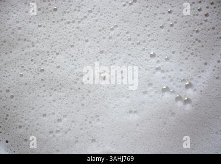 Bubbly soap foam background. Soap foam closeup. White foam backdrop. Stock Photo
