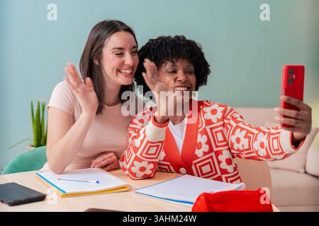 African American and Caucasian students taking selfie while studying at home Stock Photo