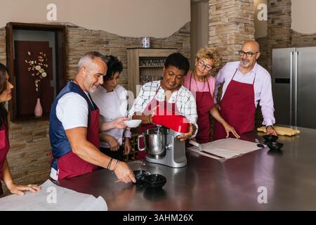 Chefs using stand mixer preparing dough in cooking class Stock Photo