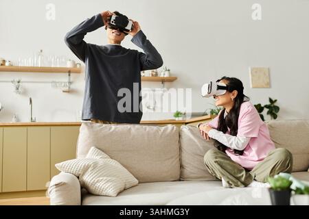 A young couple enjoys immersive virtual reality together at home, sharing special moments. Stock Photo