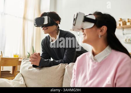 Sharing smiles and adventures, a young asian couple enjoys virtual reality experiences together. Stock Photo