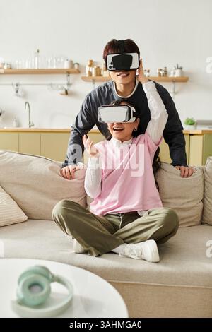 A young couple enjoys virtual reality at home, sharing laughter and joy together. Stock Photo