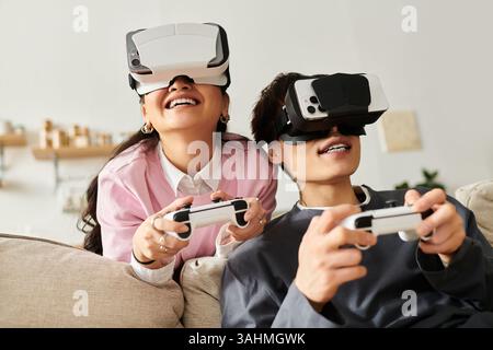 A young couple shares laughter and excitement while using virtual reality headsets and controllers. Stock Photo