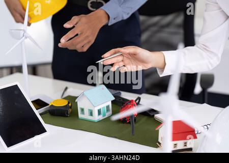 Sustainable Engineering Practices. Engineers collaborating on green housing projects and renewable energy solutions. Stock Photo