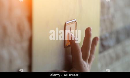 Child hand presses on button with arrow in modern lift Stock Photo