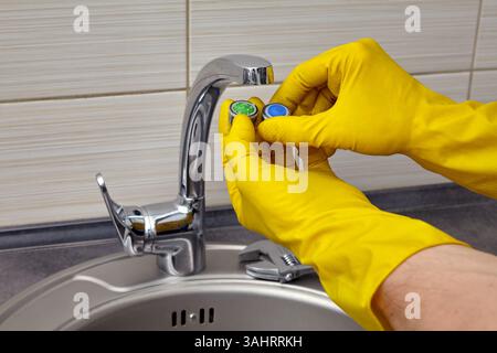 replacing a clogged faucet aerator in the kitchen sink Stock Photo