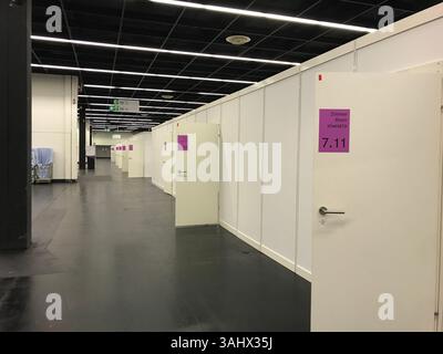 Cologne, Germany - March 23, 2022 - Large room with many doors and a sign that says 711, refugee camp. The room is empty and has a very sterile feel t Stock Photo