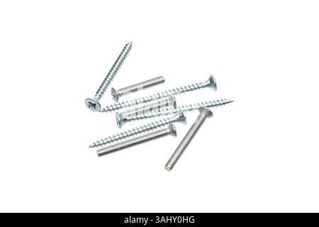 A close-up shot of silver screws scattered on a white background, highlighting various thread patterns and head designs, suitable for construction, re Stock Photo