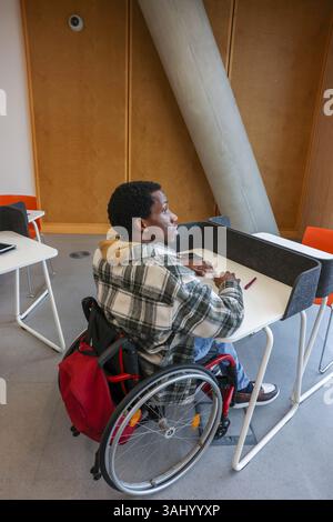 Man in wheelchair sitting in office Stock Photo