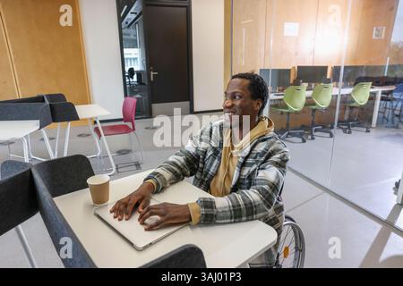 Man in wheelchair sitting in office Stock Photo