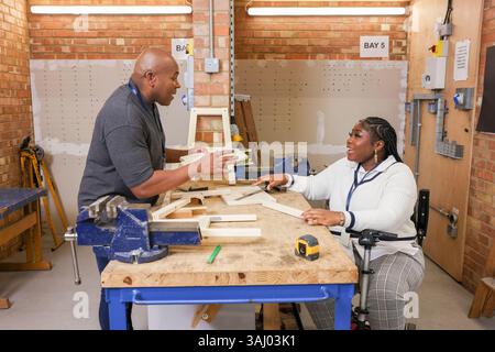 Disabled man and woman working in workshop Stock Photo