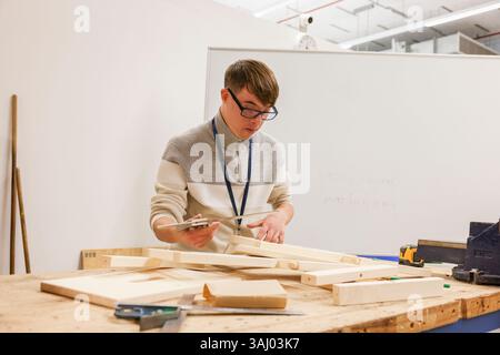 Man with Down Syndrome working in workshop Stock Photo