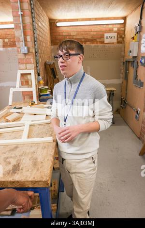 Man with Down Syndrome standing in workshop Stock Photo