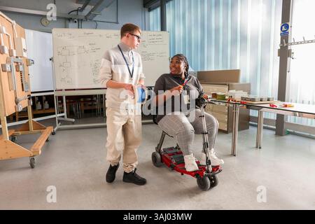 Disabled man and woman talking in workshop Stock Photo