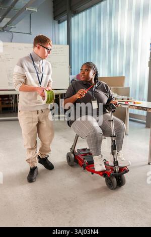 Disabled man and woman talking in workshop Stock Photo