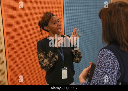 Coworkers using sign language in office Stock Photo