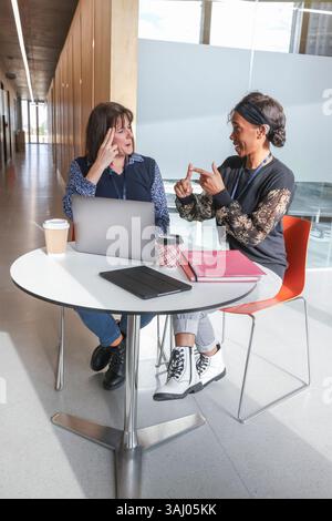 Coworkers using sign language in office Stock Photo