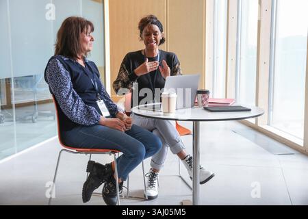 Coworkers using sign language in office Stock Photo