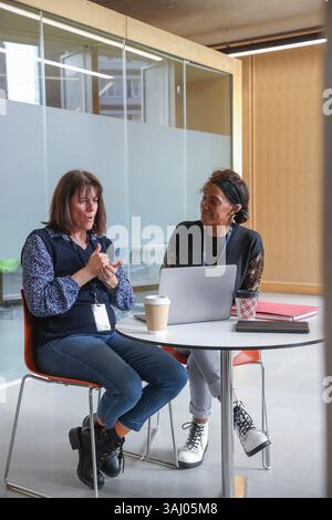 Coworkers using sign language in office Stock Photo