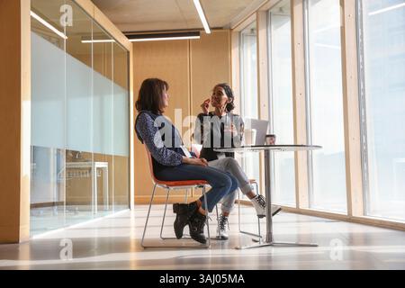 Coworkers using sign language in office Stock Photo