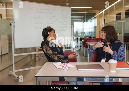 Coworkers using sign language in office Stock Photo