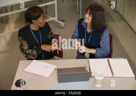 Coworkers using sign language in office Stock Photo