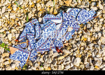 Broken ceramic tiles lying on gravel. Stock Photo