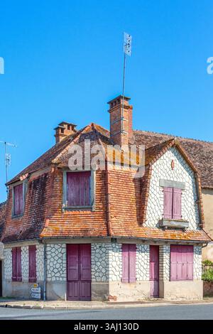 Unusual corner house with tiled sloping upper-story walls  - Saint-Michel-en-Brenne, Indre (36), France. Stock Photo