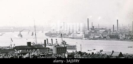 The 1909 Thames Naval Review, held on the River Thames, passes the Deptford area. On the opposite bank, the paint and dye manufacturers A. E. Burrell & Son are visible, with factories and chimneys in the background. The Northumberland engineering works, named after HMS Northumberland, built between 1861-1866, is situated to the east. Stock Photo