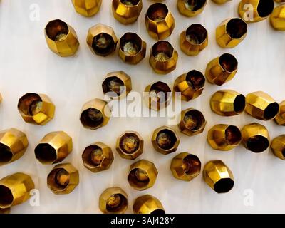 Gold geometric cups arranged in a wall display form a modern, sculptural texture—ideal for luxury décor themes and contemporary art concepts. Stock Photo