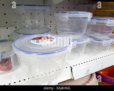 Plastic food storage containers on retail display shelf with pricing labels. Stock Photo