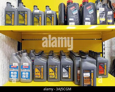Various motor oils and lubricants displayed on yellow shelves. Stock Photo