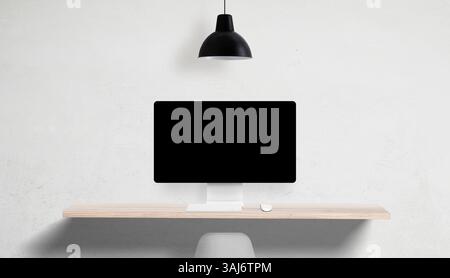 Desktop computer with blank screen on clean desk, overhead lamp and empty side space, perfect for UI mockups and marketing copy placement Stock Photo