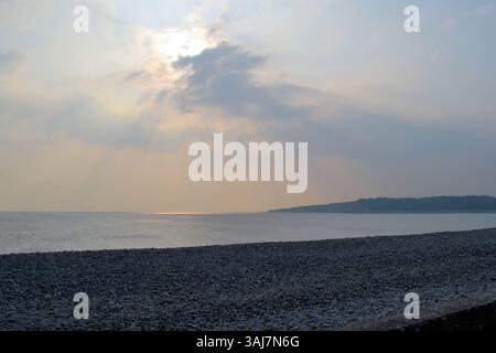 Cold Knap Beach, Barry, South Glamorgan, Wales with the sun breaking through from behind clouds Stock Photo