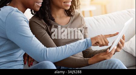 African american girlfriends using digital tablet together Stock Photo