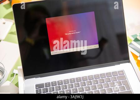 Paris, France - Mar 13, 2025: New Apple MacBook Air M4 being set up with macOS showing Siri voice setup prompt on screen, keyboard in view with fresh system installation during unboxing session Stock Photo