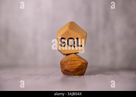 SQL - Structured Query Language - concept, cube wooden block with alphabet combine abbreviation SQL. Bright Yellow background. Stock Photo