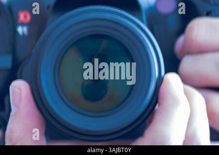 Reversed self-portrait of a man reflected in the camera lens Stock Photo