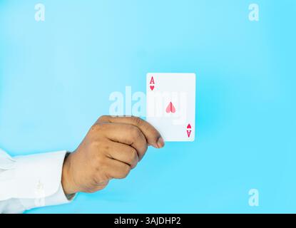 Close up hand shown a red Ace playing card on aqua background, concept of business bring out the big gun to win. Stock Photo