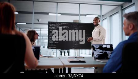 Team Of Diverse Developers Collaborate On Software Project In Boardroom. Stock Photo