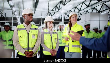 Diverse Team Of Factory Plant Engineers Train On Computer Automation. Stock Photo