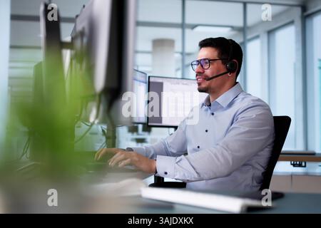 Happy Customer Support Specialist In Call Center Providing Excellent Service To Clients Over The Phone Stock Photo
